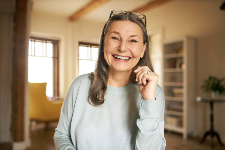 Mulher sênior sorridente com prótese protocolo, mostrando reabilitação oral para quem tem pouco osso na Clínica Gen em Higienópolis.